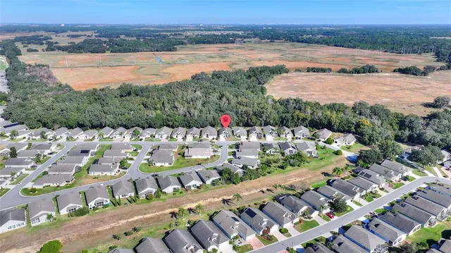 an aerial view of residential houses with outdoor space and parking