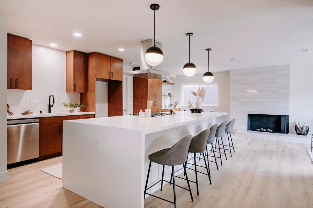 a kitchen with stainless steel appliances kitchen island granite countertop a sink a stove a dining table and chairs