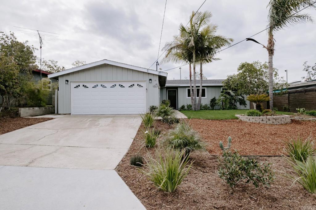 1027 San Abella Drive Encinitas, CA 92024 - Photo 23 of 27 a front view of a house with a garden and trees
