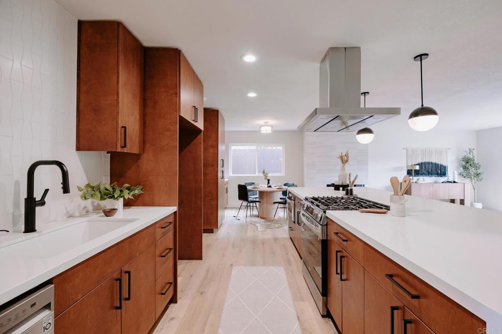 1027 San Abella Drive Encinitas, CA 92024 - Photo 4 of 27 a kitchen with stainless steel appliances a sink stove and cabinets