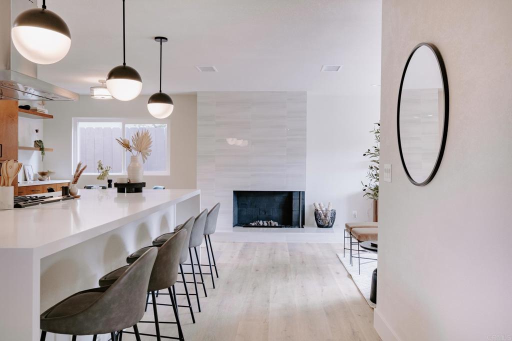1027 San Abella Drive Encinitas, CA 92024 - Photo 6 of 27 a view of a kitchen with a sink and a fireplace with wooden floor