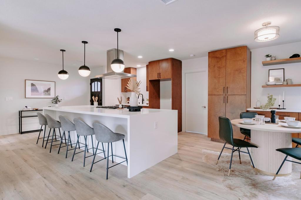 1027 San Abella Drive Encinitas, CA 92024 - Photo 7 of 27 a kitchen with stainless steel appliances kitchen island a dining table and chairs