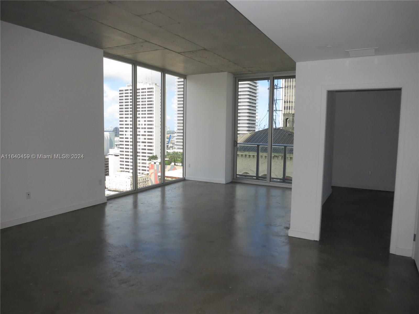 151 Southeast 1st Street, Unit 1902 Miami, FL 33131 - Photo 2 of 21 an empty room with wooden floor and windows