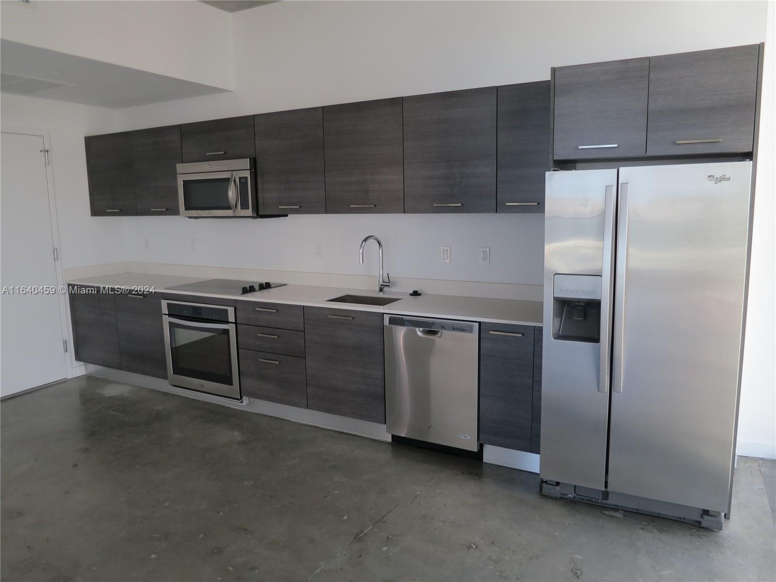 151 Southeast 1st Street, Unit 1902 Miami, FL 33131 - Photo 6 of 21 a kitchen with stainless steel appliances a refrigerator a sink a stove and cabinets