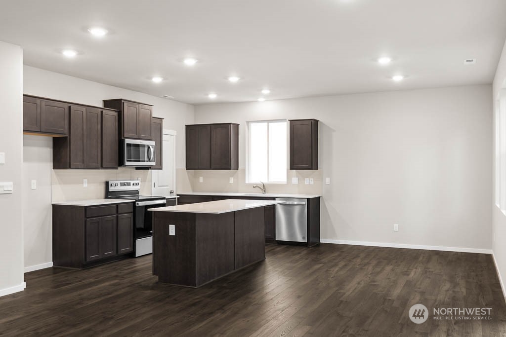 18937 Liberty Rdg Lane, Unit 955 Puyallup, WA 98374 - Photo 5 of 19 a large kitchen with stainless steel appliances granite countertop a stove top oven a sink and dishwasher