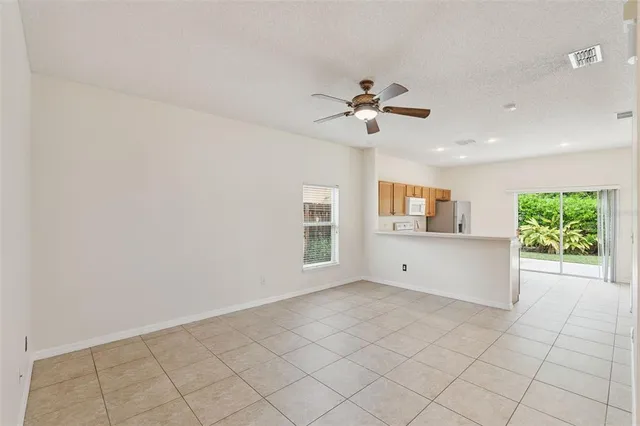 an empty room with windows and ceiling fan