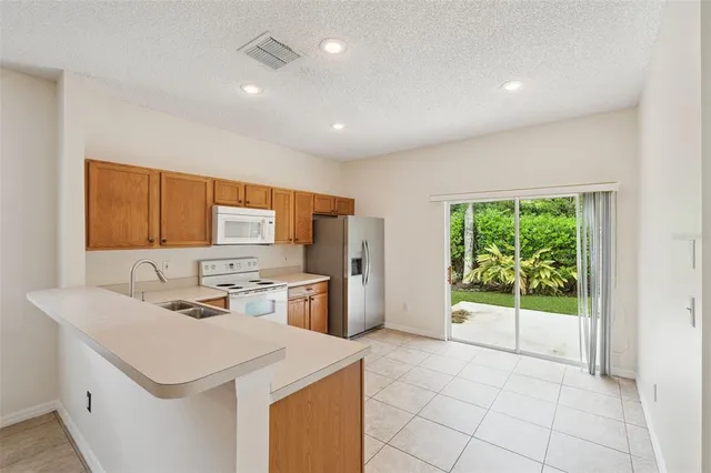 a kitchen that has a sink a stove and a refrigerator