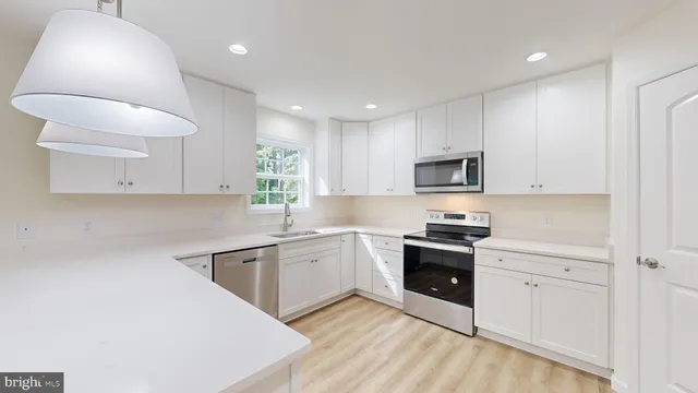 a kitchen with white cabinets and sink