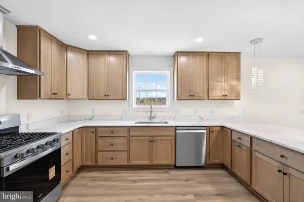 a kitchen with stainless steel appliances granite countertop a refrigerator a sink and a stove