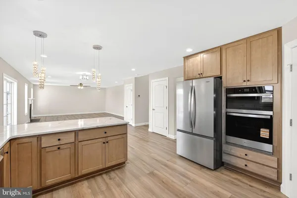 a living room with furniture kitchen view and a large window