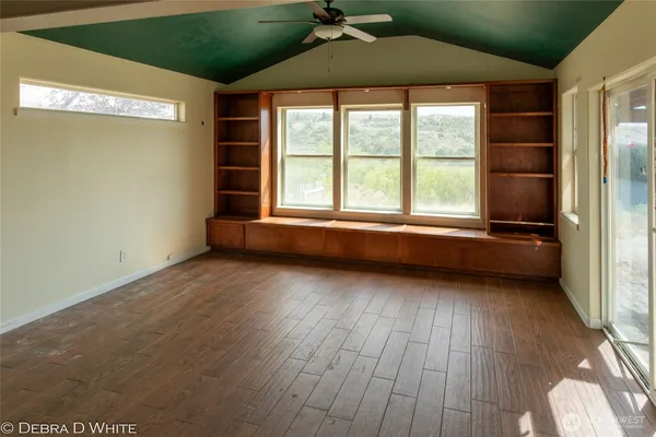 an empty room with wooden floor and a window