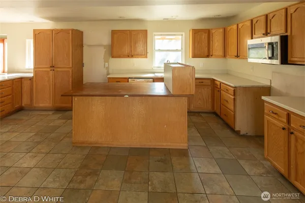 a kitchen with stainless steel appliances a sink a stove a microwave a counter top space and cabinets