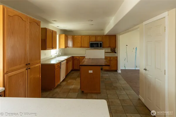 a large kitchen with kitchen island a sink stainless steel appliances and cabinets