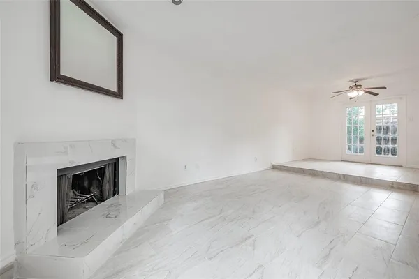 a view of an empty room with window and fire place