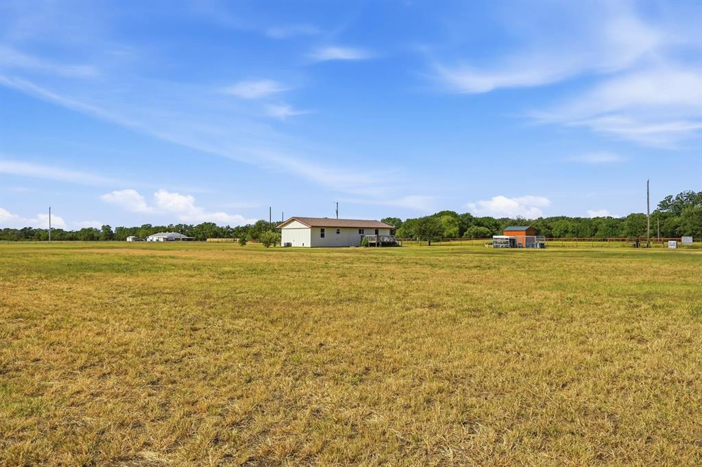 1802 Batey Road Collinsville, TX 76233 - Photo 28 of 33 Expansive open field with a single-story residence featuring light-colored siding and a dark roof