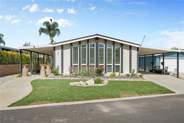 a front view of a house with a yard and potted plants