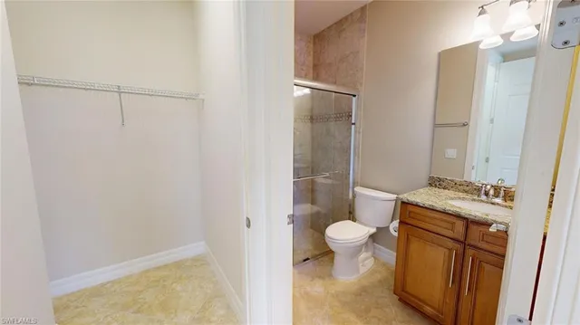 a bathroom with a granite countertop sink toilet and shower