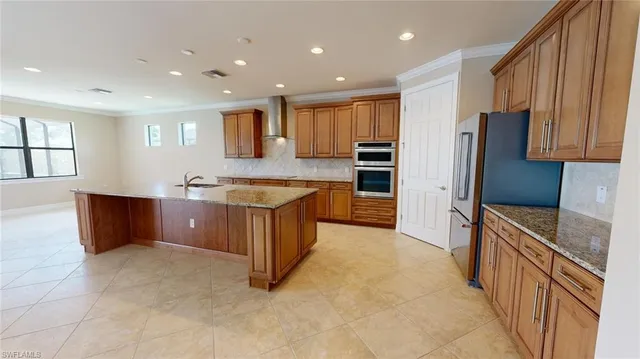 a large kitchen with stainless steel appliances granite countertop a large counter top a stove a sink and a refrigerator