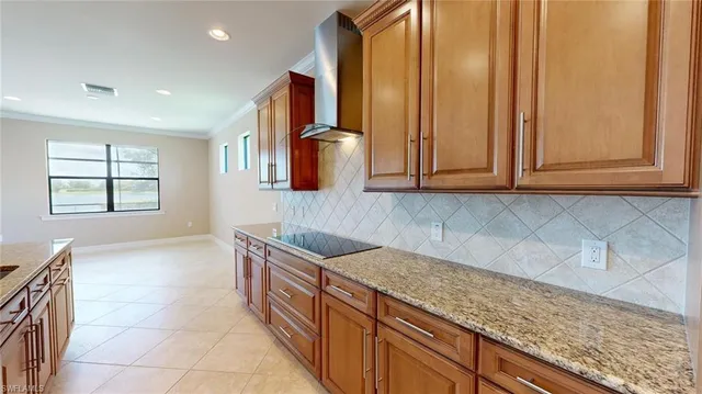 a kitchen with kitchen island granite countertop a sink a counter top space and cabinets