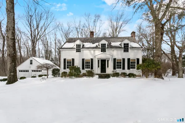 a view of a house with a yard covered in snow
