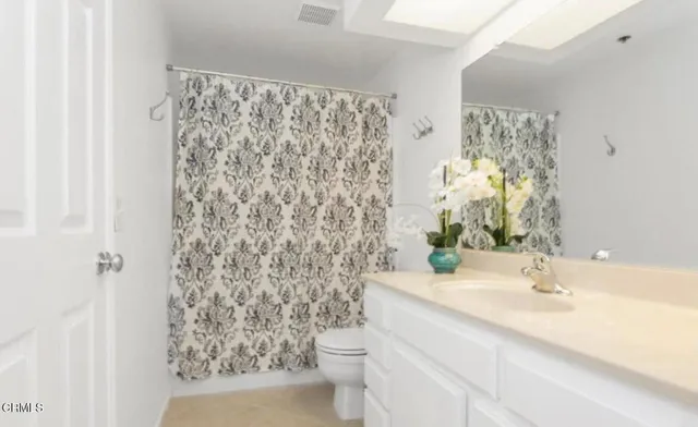 a bathroom with a sink a toilet and shower curtain