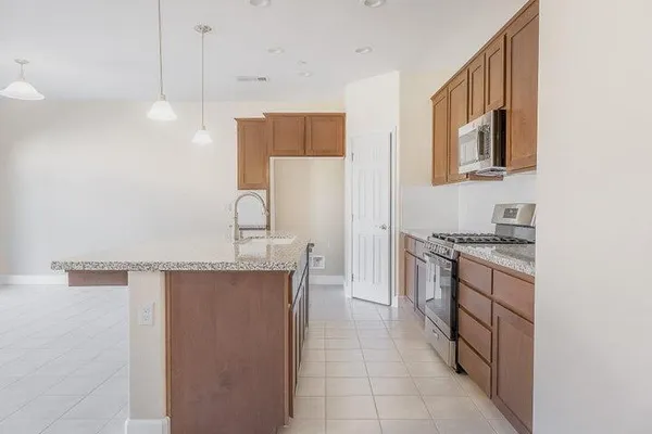 a kitchen with kitchen island a sink appliances and cabinets