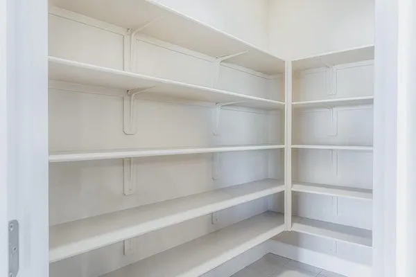 a view of walk in closet with empty racks