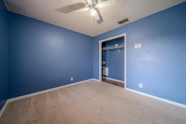 an empty room with closet and windows