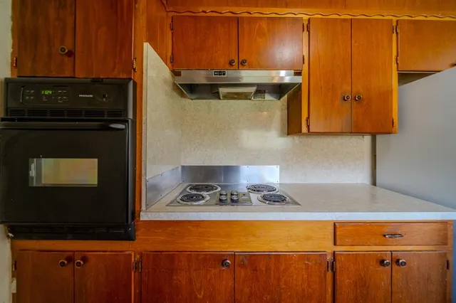 a kitchen with a sink a stove and cabinets