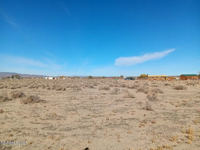 a view of a dry yard with wooden fence