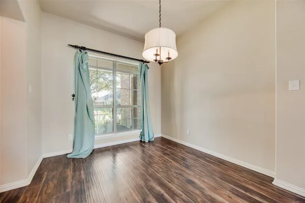 a view of a room with wooden floor water heater and a window