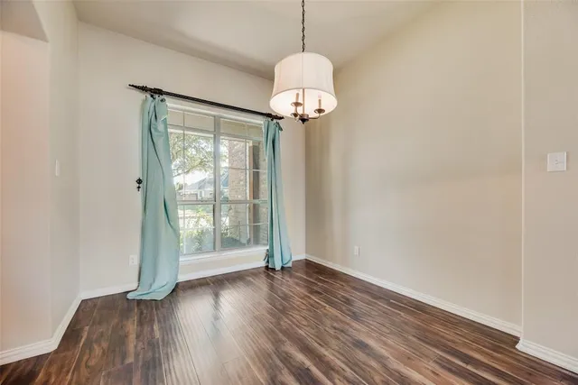 a view of a room with wooden floor water heater and a window