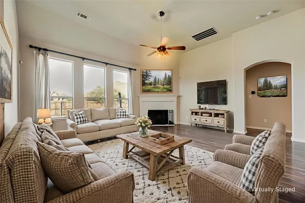 a living room with furniture a fireplace and a flat screen tv
