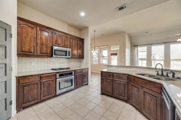 a kitchen with stainless steel appliances granite countertop a stove sink microwave and cabinets