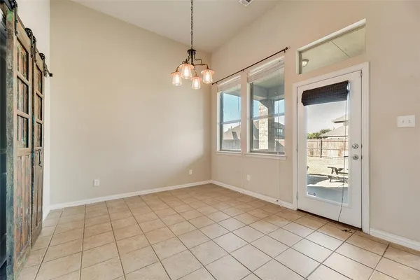 an empty room with windows and ceiling fan