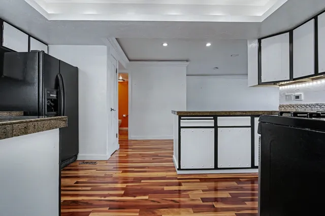 a kitchen with stainless steel appliances granite countertop a refrigerator and a stove top oven