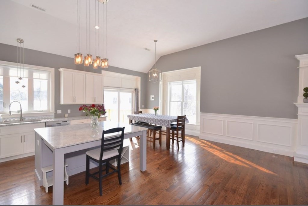 261 Main Street, Unit 1 Shrewsbury, MA 01545 - Photo 5 of 14 a dining hall with stainless steel appliances granite countertop a stove a table and chairs with wooden floor