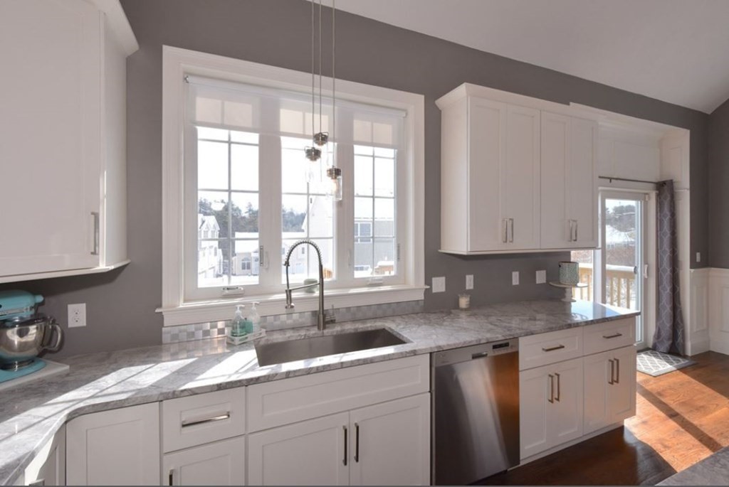 261 Main Street, Unit 1 Shrewsbury, MA 01545 - Photo 6 of 14 a kitchen with granite countertop a sink white cabinets and window