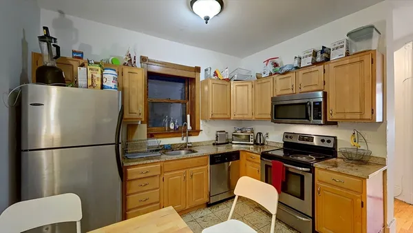 a kitchen with stainless steel appliances granite countertop a refrigerator a stove a sink and a microwave