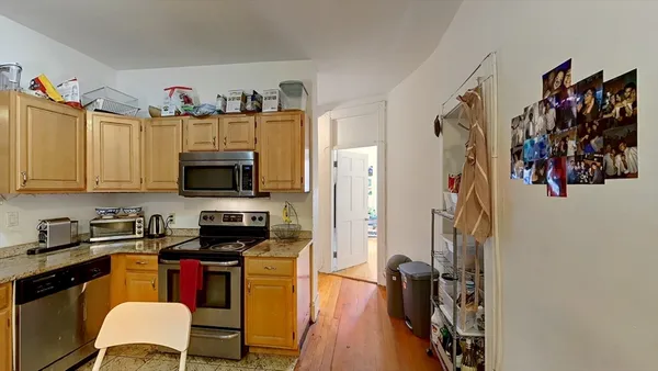 a view of a kitchen with stainless steel appliances a refrigerator and a stove top oven
