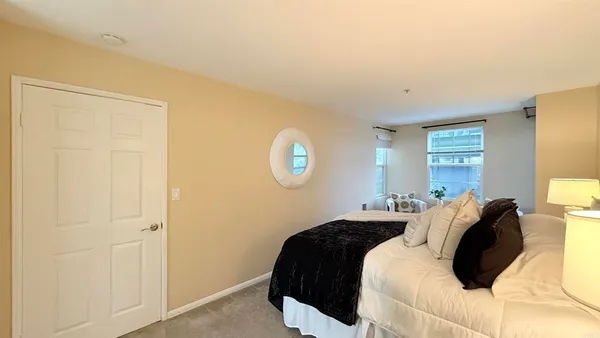 a bedroom with a bed and a lamp on dresser