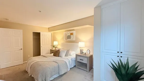 a bedroom with a bed and a potted plant