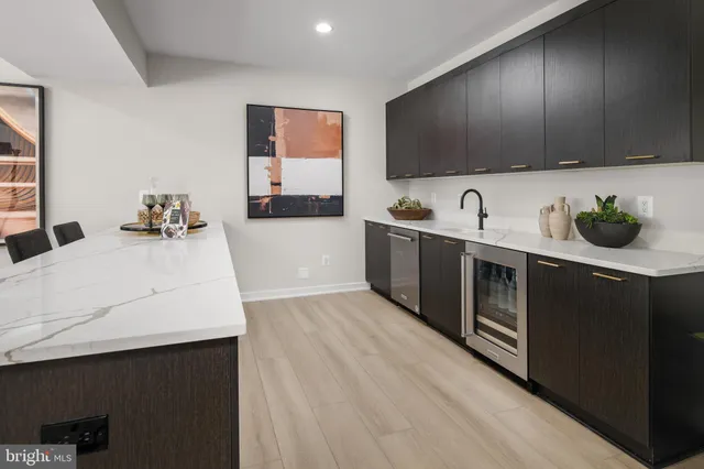 a kitchen with stainless steel appliances a sink cabinets and wooden floor