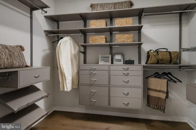 a view of walk in closet with clothes and shoes