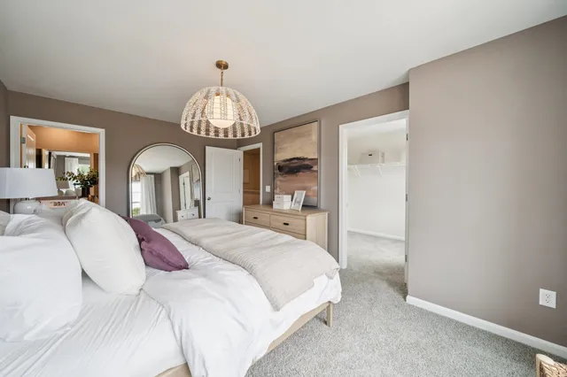 a spacious bedroom with a large bed and a chandelier