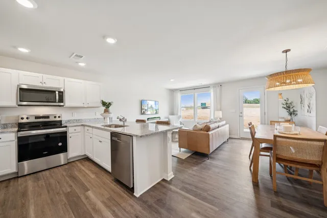 a kitchen with stainless steel appliances granite countertop wooden floors and view living room