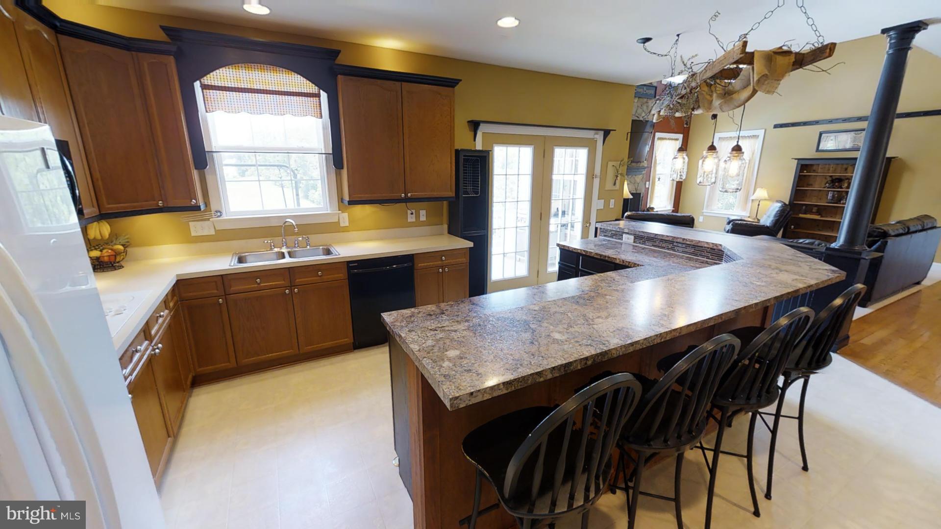 283 Rippling Waters Way Falling Waters, WV 25419 - Photo 12 of 30 a kitchen with a table chairs sink and wooden floor