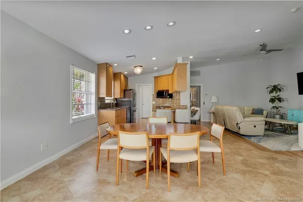 a dining room with furniture and view of kitchen