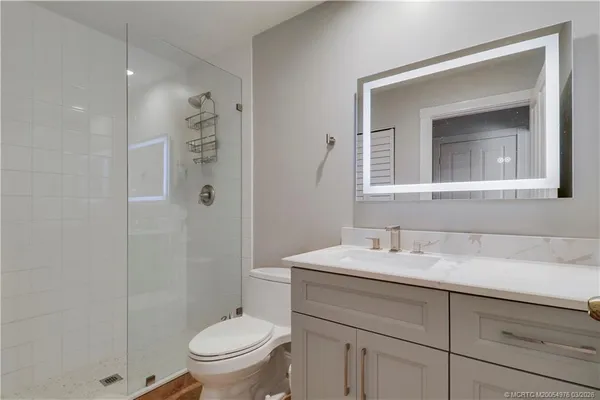 a bathroom with a sink toilet vanity and shower