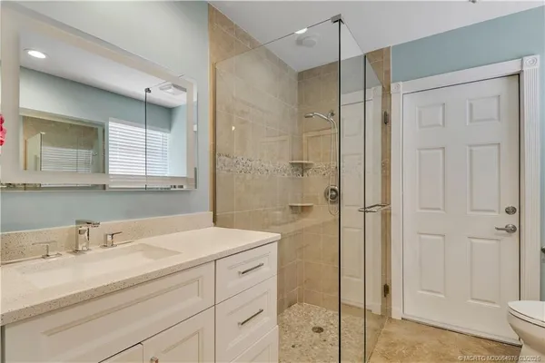 a bathroom with a shower sink and mirror